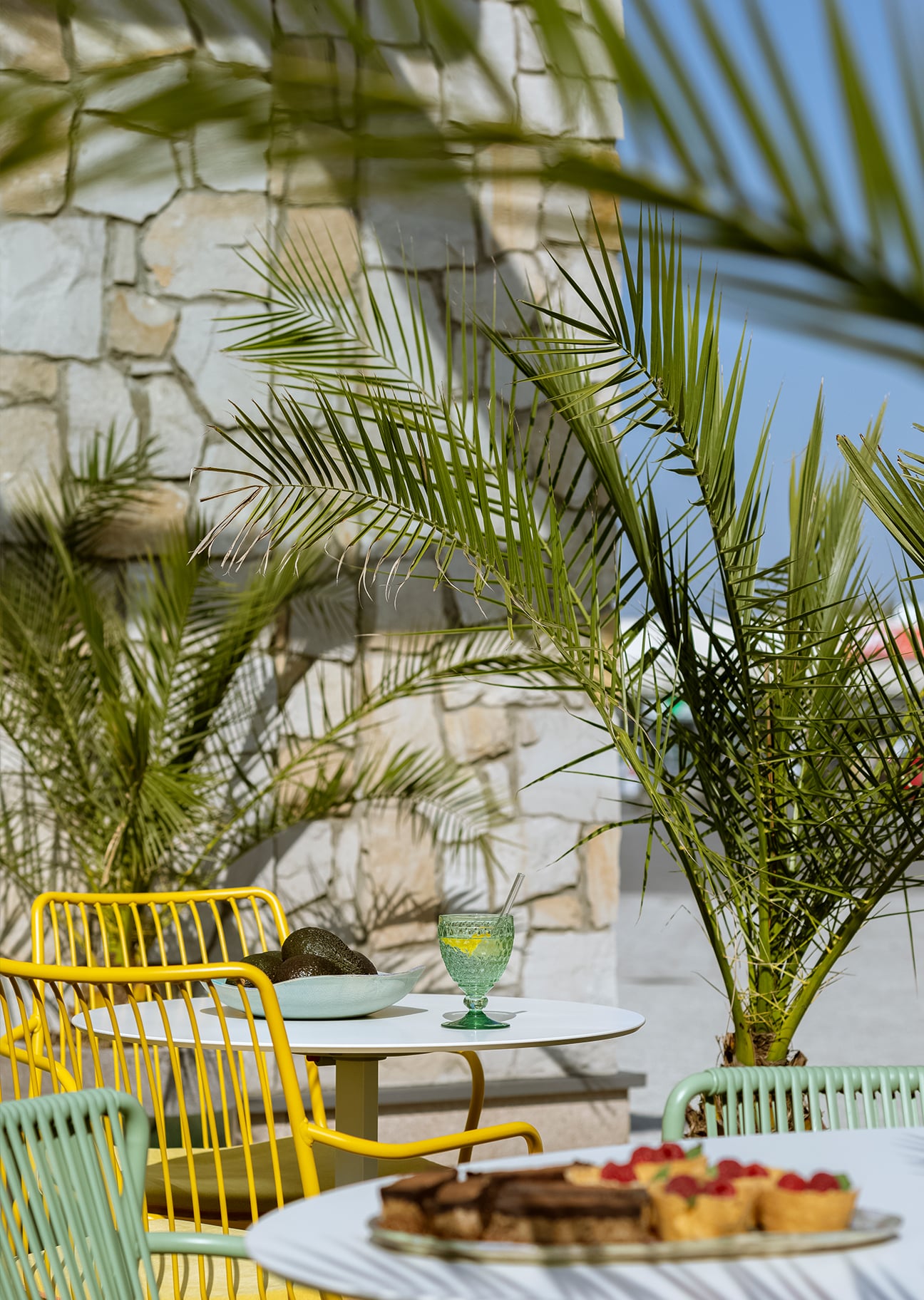 Tables in the garden among palm trees in front of Wiele Dobrego, Vogel Square.